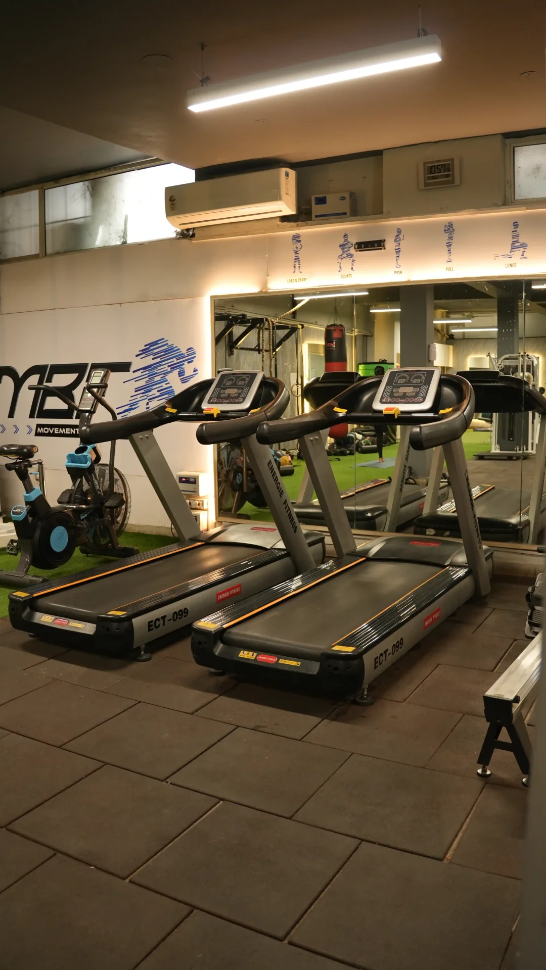 Cardio zone vertical view with treadmills and MBF logo wall
